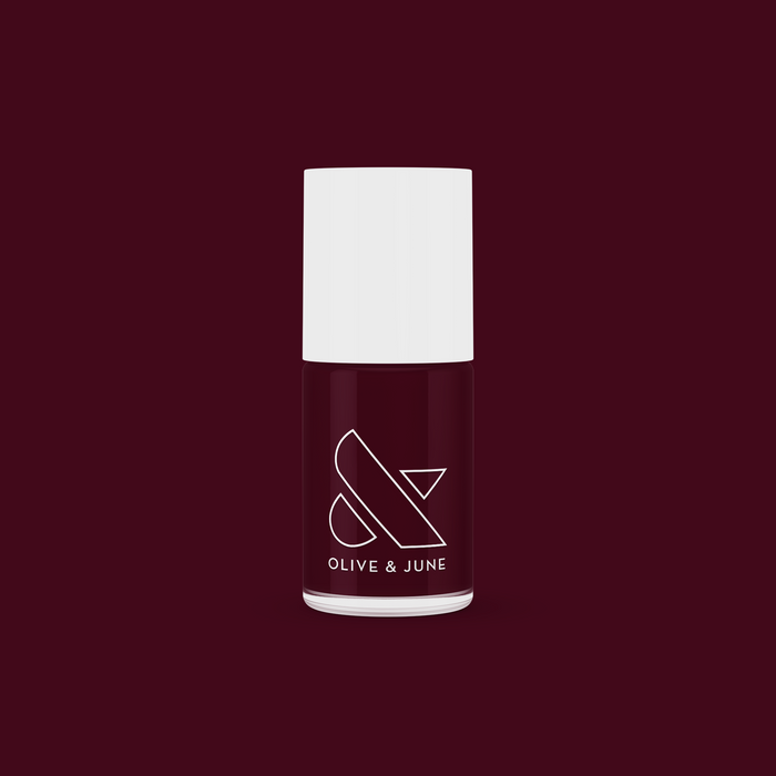 Obsessed nail polish bottle by Olive and June in dark ruby red for a smooth, long-lasting manicure finish
