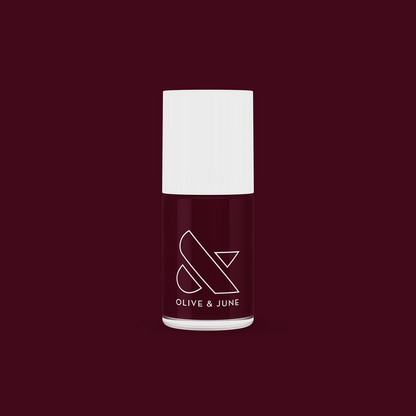 Obsessed nail polish bottle by Olive and June in dark ruby red for a smooth, long-lasting manicure finish