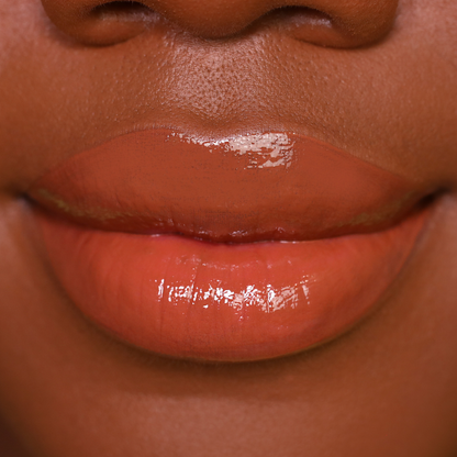 Oh Deer caramel brown lip gloss on lips, medium-deep skin tone