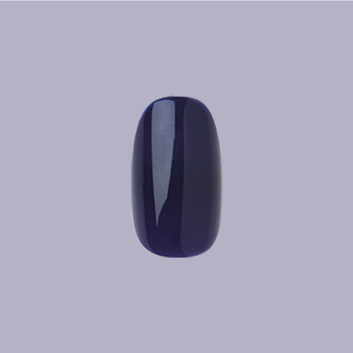 OMG - Press-On | Short | Round showing a single deep indigo short round press-on nail with glossy finish on purple background