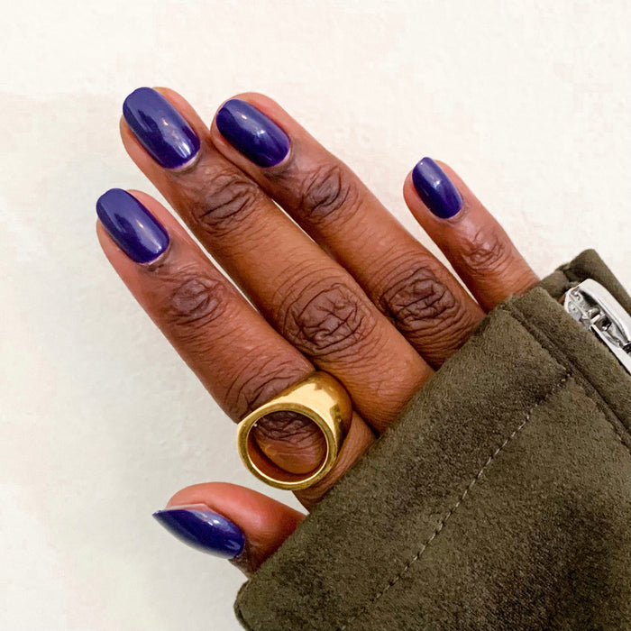 OMG - Press-On | Short | Round showing hand with deep indigo short round press-on nails against neutral background
