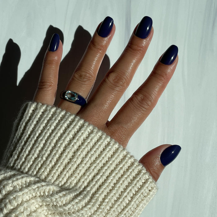 OMG - Press-On | Short | Round showing hand with glossy deep indigo short round press-on nails against white background