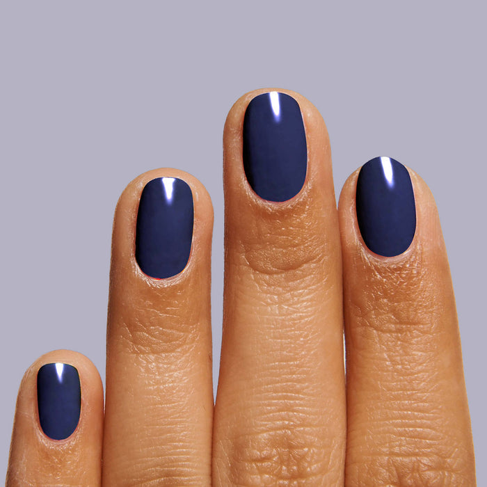 Fingernails painted in smooth, glossy deep indigo OMG polish for a sleek, long-lasting manicure by Olive and June