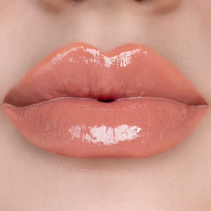 Overqualified peachy nude lip gloss on lips, light skin tone