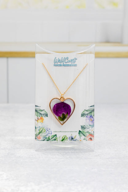 Portrait photo of a heart-shaped pressed flower pendant necklace with soft mixed dried blooms