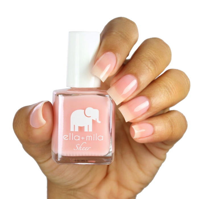Pure sheer pink peach tint nail polish on a medium skin tone, hand holding the bottle