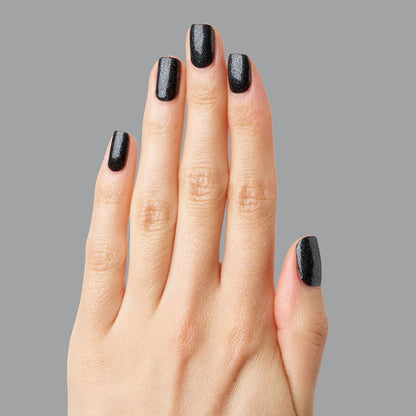 Hand with nails painted in SPACEY showing deep black shimmer polish with a glossy, long-lasting gel manicure finish