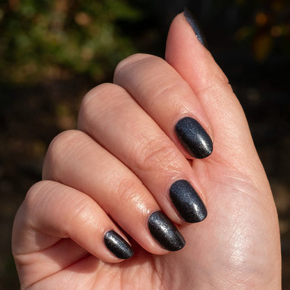 Hand with nails polished in SPACEY showing dark shimmer gel polish with a quick-dry, long-lasting manicure finish