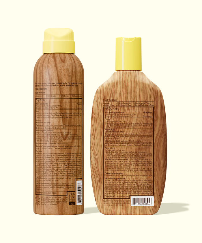 Back view of Sun Bum SPF 50 Spray + Lotion bottles with detailed ingredient and usage information on wood-textured packaging.