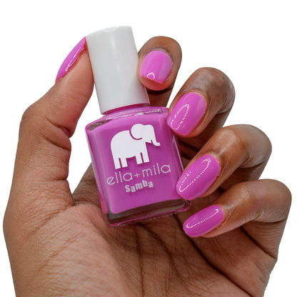 Staycation Vacation fuchsia nail polish on a deep skin tone, holding the bottle