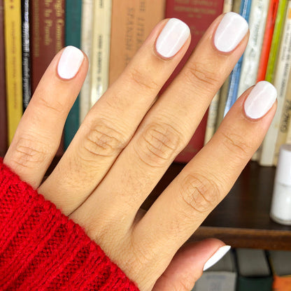 Hand with nails painted in STELLAR polish showing a smooth, long-lasting manicure with subtle sparkly white shimmer finish