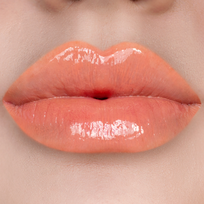 Strapless peach coral lip gloss on lips, light skin tone