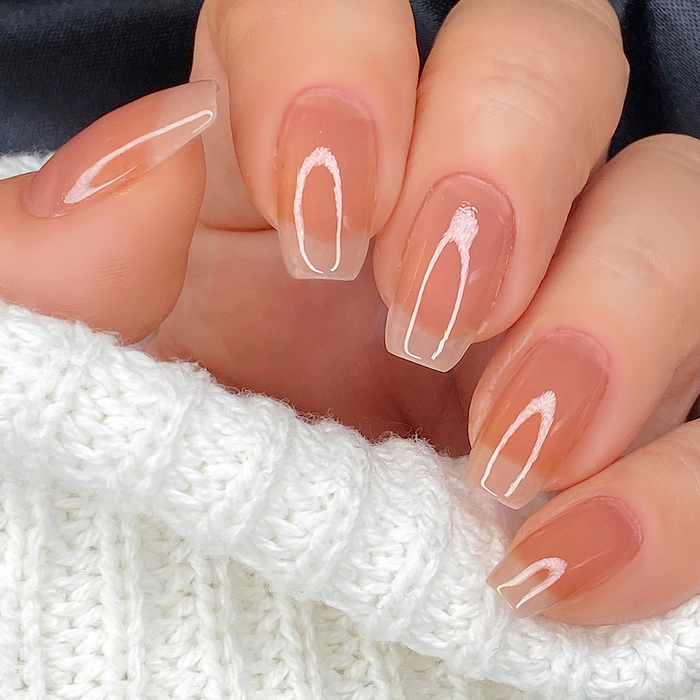 Strong sheer mauve nail polish close-up on a light skin tone with a white sweater