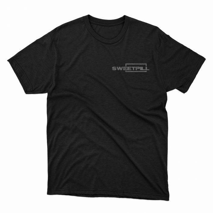 A plain black Sweet Pill T-shirt features the brand name in bold white letters with a rectangular outline on the upper left chest. The exclusive design is displayed flat against a white background.