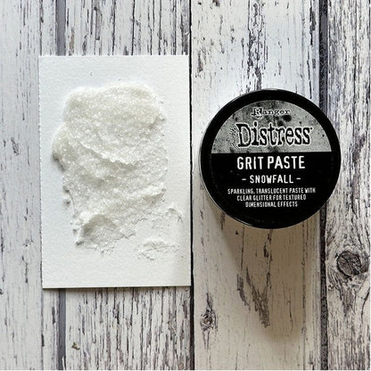 Tim Holtz - Distress Grit Paste - 3oz - Snowfall.  Add a touch of texture to Winter Holiday creations. Snowfall Grit Paste is a dimensional translucent medium infused with a clear glitter that dries to a textured sparkle finish. Available at Embellish Away located in Bowmanville Ontario Canada.