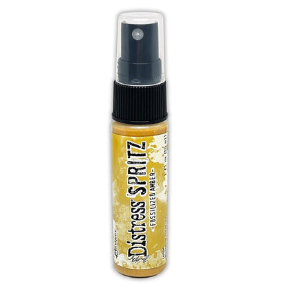 Tim Holtz = Distress Spritz 1oz Bottle - Select from Drop Down. Uncharted Mariner, Picked Raspberry, Spiced Marmalade, Fossilized Amber, Peeled Paint, Twisted Citron, Worn Lipstick, Walnut Stain, Wilted Violet, Barn Door, Weathered Wood, Peacock Feathers Available at Embellish Away located in Bowmanville Ontario Canada Fossilized Amber