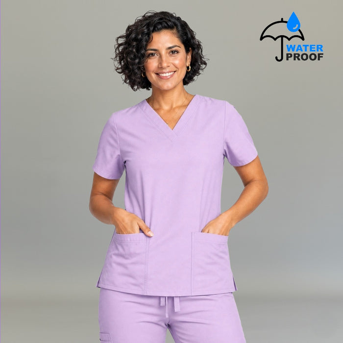 Women's lilac lightweight scrub top 502 V-neck front view with both hands in pockets — fluid-resistant medical uniform by S-FOR-ME