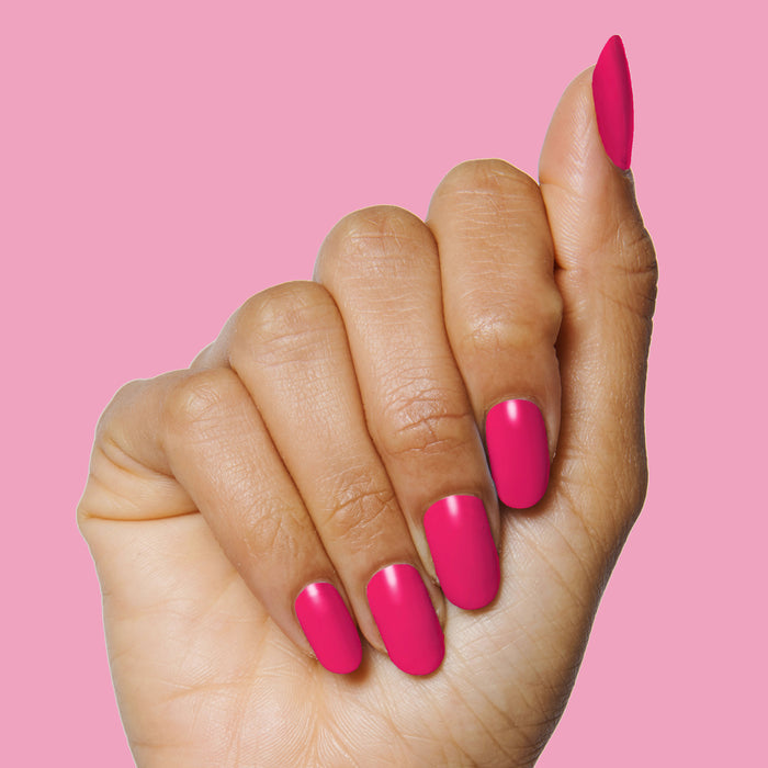 Hand with smooth, bright hot pink nails painted with XOXO long-lasting polish on a solid pink background