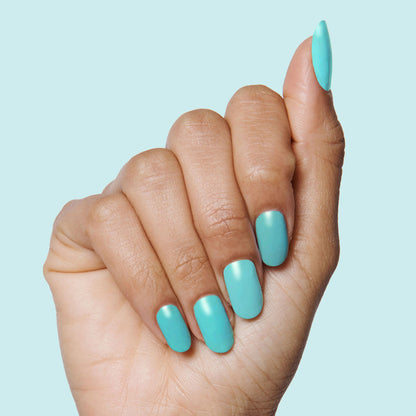 Hand with nails painted in vibrant turquoise using Yes Please polish for a smooth, long-lasting manicure by Olive and June