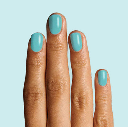 Fingers with nails painted in turquoise using Yes Please polish for a smooth, long-lasting manicure by Olive and June
