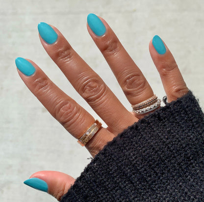 Hand with nails painted in vibrant turquoise shade Yes Please for a smooth, long-lasting manicure by Olive and June
